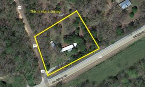 This acre of land sits on the corner of Hwy 905 and facing Hwy 412. Trees and foliage provide privacy and convenience. A perfect spot to build your next home or utilize the existing mobile in need of extensive remodel. The mobile conveys at no additional value to the property. There is a well, covered carport, and storage building. The property has mature landscaping that with a little TLC will provide a beautiful yard.