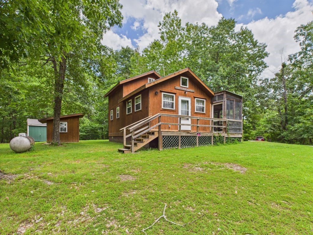 Redbud Cottage is a fully furnished cabin, accessible a private, well-maintained one-mile gravel road. It features a lower-level BR & BR in the upper-level loft. Fully equipped kitchen with appliances, & screened porch, a covered picnic area, & outdoor fire pit. The cottage is air-conditioned & has gas heating for year-round comfort. The property includes six off-grid furnished cabins, a kitchen pavilion, and a sauna, with water connected through a rural supply, well and septic system. Connecting with parkland at Buffalo Point, the property offers stunning views & access to Panther Creek & the Buffalo River. Whether you prefer floating on the Buffalo River, fishing in the White River, or relaxing by the fire pit, this property promises a delightful experience. It has been recognized as an official "Dark Sky" cottage by the Arkansas Dark Sky Association since 2021. Ample parking is available for vehicles & outdoor gear, easy access to nearby attractions like the Buffalo National River & the historic Rush District.