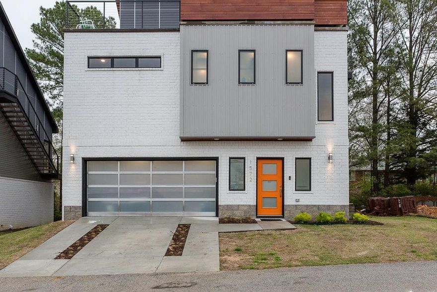 A striking architectural residence where sophisticated design meets elevated living. This contemporary 3 BR 2.5 BA home was thoughtfully crafted for refined entertaining, highlighted by an extraordinary patio with a raised glass garage door overlooking the living space below—an unmistakable statement of modern luxury. The open concept interior is flooded w/natural light showcasing soaring wood ceilings, expansive windows, hardwood floors, industrial inspired kitchen w/quartz countertops. A dramatic balcony w/retractable glass door opens to private rooftop terrace & LR below & breathtaking panoramic views of Fayetteville. MBR serves as a serene retreat, accentuated by designer feature wall and a spa inspired bath w/an oversized walk-in shower. Other BRs offer generous proportions and refined comfort. Ideally located just minutes from the downtown square and entertainment district, this one-of-a-kind property delivers exceptional style, coveted amenities, and outstanding potential as a luxury investment property.