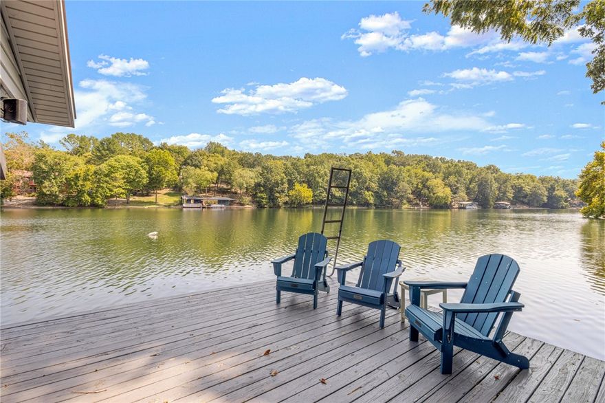 Gorgeous Lake Front Home w/ Private Dock! This 4-bedroom home features a great layout, large circle drive, and 3 level outdoor living space. The main level living space has beautiful tongue & groove ship lap ceiling w/ wood beam. Living room has brick wood burning fireplace & stunning lake views. Kitchen has been renovated w/new appliances & granite counters. Primary bedroom on main level w/fully remodeled bath w/ large walk-in shower, double vanity & WIC. Two guest beds and one bath on other side of the home. Downstairs is a full second living area with living space & full kitchen. One full bath/laundry. 4th bedroom has attached bath. Flex room for 5th bed/office/game room. Enjoy your lakeside setting from the expansive outdoor living areas, both covered and uncovered decks as well as stairs to your private boat/swim dock! Workshop under the home w/crawlspace storage. Easily accessible to Bentonville & I-49. Community amenities include golf, lakes, mountain biking trails & downhill park, gyms, pools & more!