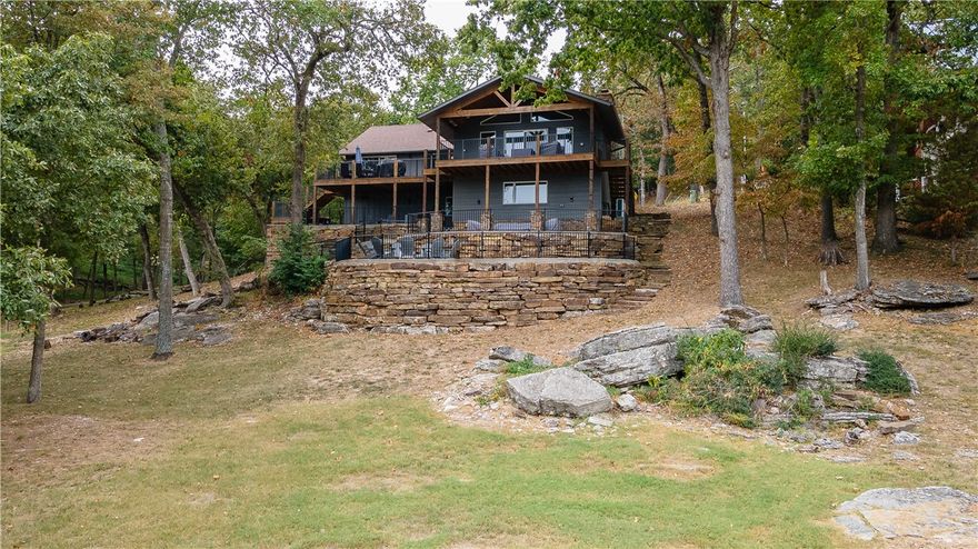 Looking for a lake front home that is REMODELED with year round lake views and a private dock? This is IT! 3,294 heated and cooled sq ft offers 5 bedrooms, 4 full bathrooms, Eat-In-Kitchen, dining room, den, oversized living, game room, and 2 laundry’s. Other amenities include LVP flooring throughout, granite countertops, commercial grade ice maker, wet bar, 2 wood burning fireplaces, radiant heat on the deck, fire pit, 2 car garage, over 1,000 sq ft of outdoor living, and a private 1 stall boat dock w/ a swim platform that is a gentle walk to get to! The POA offers a maintained scenic walking trail right across the street! This property is on all paved roads and has full service for grocery/food delivery if you should choose! Did I mention that the furnishings are beautiful and convey? Don’t miss the opportunity to enjoy all of the seasons on Beaver Lake.