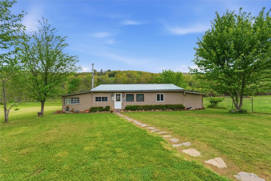 Peaceful acreage with true off-the-grid charm! This 3.86-acre property offers a 1,030 sq ft home surrounded by scenic views and natural beauty, complete with a creek running through the land that adds to the tranquil setting. The home operates on a rainwater system, creating a self-sufficient, eco-friendly lifestyle perfect for those looking to unplug and unwind. Existing septic and electricity are already in place, offering convenience while maintaining that rustic feel. The property also features an 18x30 shed with electricity—ideal for a workshop, storage, or hobby space. A rare opportunity to own a private retreat with space, serenity, and endless potential.