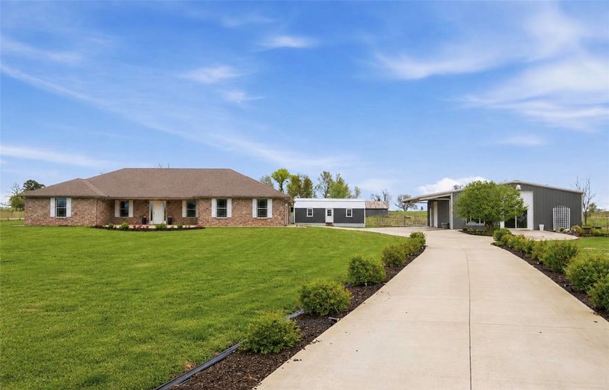 Rare opportunity in the heart of Farmington - w/ 2 dwellings, 2 acres, 1,010 SF shop, greenhouse & gardens. The 2,427 SF all-brick main home offers 4 bedrooms, 3 full baths, mudroom, home office, XL bonus room, and storm shelter. 2023 renovations include flooring, paint, lighting, appliances, fireplace, 2nd HVAC & extended entertaining patio. The 40x50 metal building includes a fully finished 990 SF studio apartment/guest house (2023) - w/ its own address, septic system, full kitchen, full bath, & laundry - ideal for multi-generational living, guest quarters, rental income etc. The remaining 1,010 SF is excellent shop/workshop/garage space w/ dual overhead doors & mezzanine storage. A separate 32x15 insulated, heated/cooled outbuilding w/ power offers even more flexibility & workspace. Outside, enjoy ample parking, raised garden beds, chicken coop & peaceful views backing to farmland for added privacy - all within walking distance of Main Street, schools/restaurants/amenities & just minutes to Fayetteville.