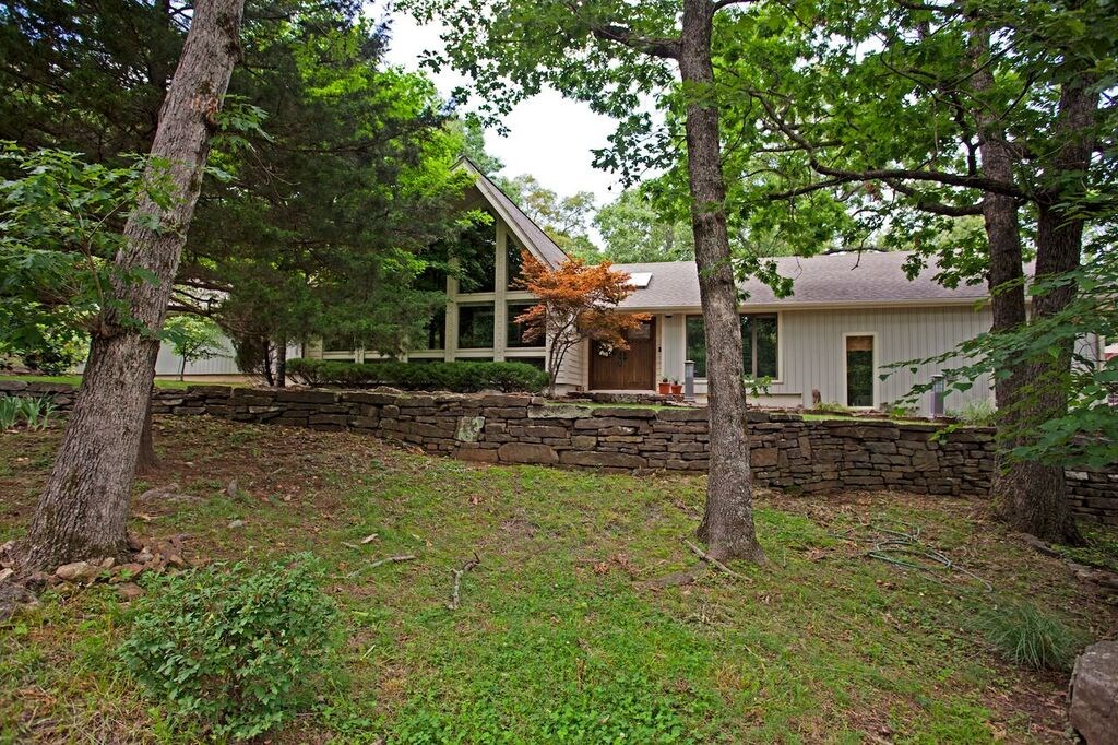 Welcoming serenity, privacy & back to nature setting awaits you at this architecturally designed one of a kind home nestled in a wooded setting just minutes from U of A, shopping & Interstate. Designer kitchen w/built-in refrigerator, 6 burner gas cook top, over-sized sink, convection oven, granite counter tops & cherry cabinets. Living rooms & bonus room: 18’ cathedral ceilings. 300SF sunroom, recently built 2 car carport, 350SF deck & 192SF storage building. Don't miss this stunning home in Hyland Park!