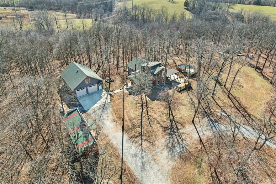5-ACRE + CUSTOM HOME + 1160 SQ/FT SHOP. Live the dream at Pear Blossom - no covenants or restrictions. This home has it all - 5 gently rolling acres behind gate, custom rustic home, all-season spring, and outdoor living. Every man's dream - detached shop that has foam insulated walls, propane stub out, 110/220, upstairs unfinished loft wired for future HVAC. Come home to rich wood beams, woodburning fireplace with blower, a cook's kitchen, both primaries on first floor, and beautiful custom rock walkways around property. Roof 2019, HVAC 2012, on demand gas water heater. Gate is 1/2 mile off pavement. Above ground pool & deck, 2024 & 8'x40' retro-fitted container onsite. The perfect use of space and design lends to a cozy and energy efficient home at Pear Blossom. Please request complete amenities portfolio and 2021 survey of property from your real estate professional. Virtual staging was used in living room and dining room. Ask your real estate professional about our $4000 buyer credit with our preferred lender.