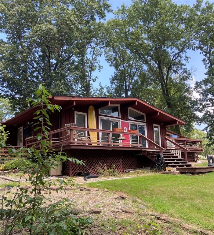 Cute as can be adorable 1967 built home with 1,023 sqft home with 2 bedrooms, 1 1/2 baths, This home is nestled on a corner lot. Amazing 0.41 acre lot with tons of trees and grassy area. The home feels private and cozy. Windows galore in this cutie with high ceilings with beams. Beautiful rock fireplace. Wonderful decks all around. This house would make a great Daily BNB. And oh...you gotta love the bike trails and lakes and all the other goodies Bella Vista has to offer!