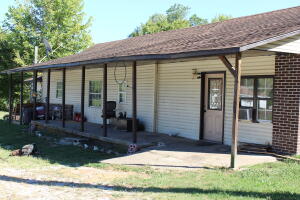 Investors check out this property! This is a 3 bed 2 bath home with a 4th room that could be office. The large open living area has vaulted ceilings and the home sits on 4 lots. The large covered porch could be a great space to sit and drink coffee. This home needs some TLC, but could be a great home. It is being sold AS IS.