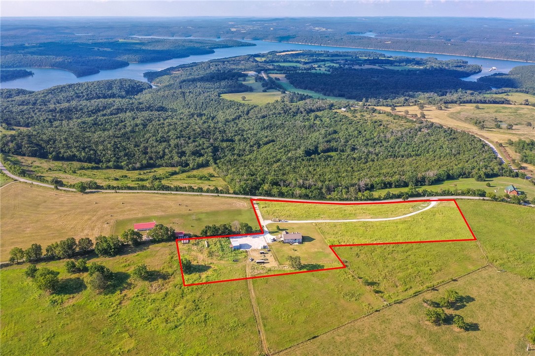 Rare opportunity awaits with this exceptional 4 bedroom, 3 bath home encompassing an office space on approximately 9.58 acres of sprawling land. Enjoy picturesque lake views and a meticulously maintained backyard pasture. This property boasts a 2-car attached garage and a separate garage adjacent to a custom working cattle pen, all set against the backdrop of an idyllic rural landscape. With approximately 20-30 bales of hay harvested per season, this property is a dream for equestrian lovers and those seeking a hobby farm lifestyle. Located just 2 miles from Tucker Hollow Marina, a mere 25-minute drive to Harrison, and only 35 minutes away from the vibrant town of Branson, MO. Experience the perfect blend of luxury and tranquility in this countryside sanctuary.