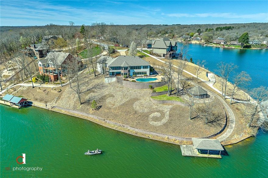 Enjoy owning the most gorgeous panoramic views on your very own 1.16 acre peninsula with this absolutely stunning lake front home on the beautiful Loch Lomond!  Easy lake access from your boat dock.  Relax in the private in-ground salt water pool or soak on a cool night in the 10 person hot tub.  This home is an entertainer's delight with 2 large living areas, chef's eat-in kitchen, wet bar and a formal dining room.  Large office area could be used as a 5th guest room.  Conveniently located just minutes from the Bella Vista Bypass.  This amazing property is priced to sell and won't last long. Schedule your private tour today!