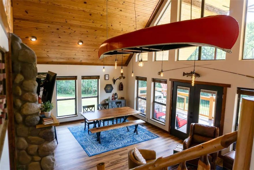 Peaceful refuge w/scenic views of the White River, one of the most beautiful retreats w/ river access between Beaver Lake & Table Rock. LAUNCH YOUR BOAT FROM THE RIVER FRONT ACCESS, FISH THE RIVER OR CRISE TO TABLE ROCK LAKE. This lodge combines rustic charm w/ modern comforts. Featuring cathedral wood ceilings, an open floor plan, a river rock fireplace, the signature red canoe lighting feature & a master bedroom ensuite. French doors lead to an expansive covered deck ideal for outdoor grilling with ample seating, overlooking the landscape and river.
Upstairs, a loft includes a custom entertainment nook, two uniquely furnished bedrooms w/ artisan-crafted reclaimed oak bunk beds, and a full bath. The walkout basement offers a bedroom, full bath, extra storage, a safe room, and a second living area, with access to an outdoor fire pit and saltwater hot tub. Near the river, enjoy an outdoor pavilion  w/a kitchenette, bath, and seating area, plus an additional secure space for vehicles and equipment. Ask 4 Updates PDF