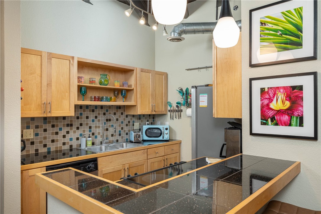 Fantastic, well-maintained condo in the heart of Fayetteville—just moments from the University of Arkansas, the entertainment district, Dickson Street, the Historic Downtown Square, and more. Featuring an open floor plan with hardwood floors throughout the living area, this modern space is filled with natural light from the huge windows in both the living area and bedrooms. The secured-entry building includes two parking spots, lovely green space, and extra storage, making it an excellent choice for a weekend retreat, investment property, or easy, low-maintenance living. Industrial flair shines through with exposed beams, while the kitchen offers granite tile countertops, natural wood cabinetry, and a bar for casual dining. Enjoy a vibrant urban lifestyle with Fayetteville’s finest dining, shopping, and events just minutes away.