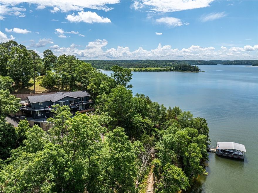 Stunning, newly remodeled lakefront home with private boat slip on 0.70 acres at Sugar Hollow Point on Beaver Lake! This secluded retreat offers incredible privacy on a quiet point with panoramic water views from nearly every room. Featuring 3 bedrooms, 3 baths, 3 living areas & a bonus room, the spacious open layout is perfect for lake living. The private primary suite includes a private terrace & an adjacent spa-like bath. Kitchen offers abundant cabinets, counter space & a large pantry. Two expansive decks overlook the lake, ideal for relaxing or entertaining. Extensive updates: new roof/gutters, HVAC, water heater, remodeled bathrooms & laundry room, new light fixtures, paint, wood flooring, new deck seal/paint, landscaping with lighting, plus power to the dock & new boat lift just to name a few! Must see to appreciate the view from one of the 3 private decks! Don’t miss this rare opportunity to own a beautifully updated lakefront home on one of Beaver Lake’s most private and sought-after points!