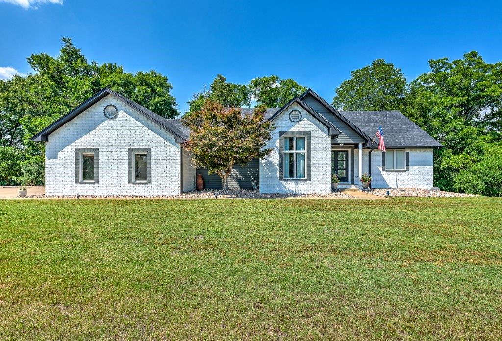 Stunning and immaculate Lake area retreat on over one acre lot, just minutes to downtown Rogers! Private boat slip/lift in community dock! Beautifully updated, 2 level white brick home, nestled on a cul de sac in Mountain Lake Estates, near Beaver Lake! 4 bed, 2.5 bath, 2 living areas, wet bar and office/study! An expansive deck runs length of home with 3 separate access points, overlooking peaceful wooded and nature views! Main level features an open living space, with spectacular cathedral ceiling, that includes kitchen, dining, living, island with raised bar, and stainless appliances! Eye-catching wood flooring with tile inlay in living area! Master bedroom boasts wood look ceramic tile, sliding barn door entry to large bath and walk in closet. Marble tile, relaxing soaker tub, and shower! Lower-level features 3 spacious bedrooms, full bath, large living/entertaining area, storage and inviting wet bar! Stained concrete and walkout basement! Entertainer’s dream!
