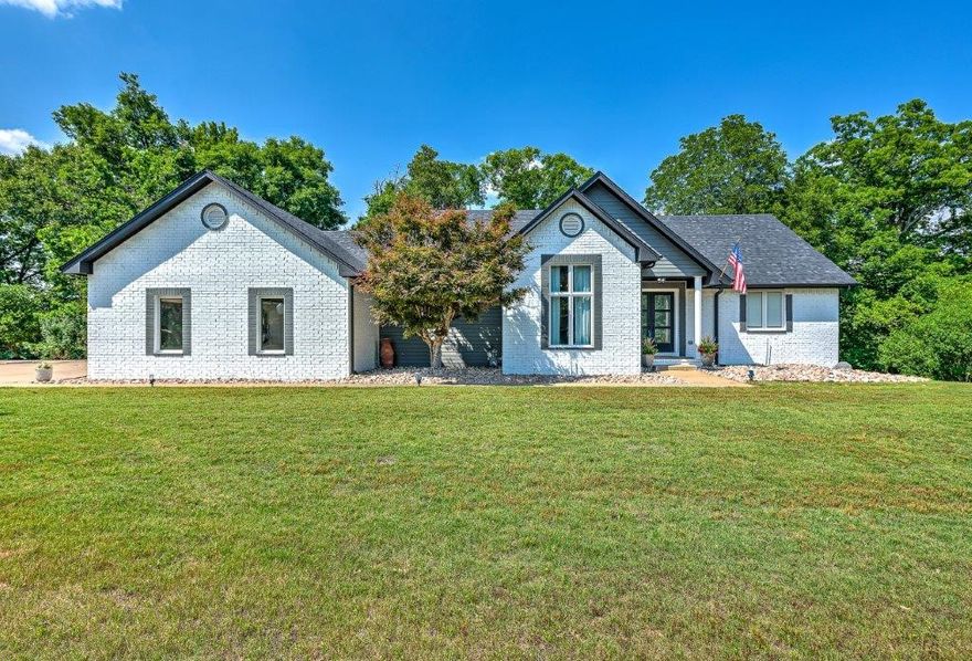 Stunning and immaculate Lake area retreat on over one acre lot, just minutes to downtown Rogers! Private boat slip/lift in community dock! Beautifully updated, 2 level white brick home, nestled on a cul de sac in Mountain Lake Estates, near Beaver Lake! 4 bed, 2.5 bath, 2 living areas, wet bar and office/study! An expansive deck runs length of home with 3 separate access points, overlooking peaceful wooded and nature views! Main level features an open living space, with spectacular cathedral ceiling, that includes kitchen, dining, living, island with raised bar, and stainless appliances! Eye-catching wood flooring with tile inlay in living area! Master bedroom boasts wood look ceramic tile, sliding barn door entry to large bath and walk in closet. Marble tile, relaxing soaker tub, and shower! Lower-level features 3 spacious bedrooms, full bath, large living/entertaining area, storage and inviting wet bar! Stained concrete and walkout basement! Entertainer’s dream!