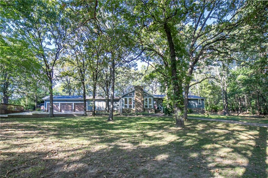 Looking for privacy and space on over 2 acres, but near shopping, restaurants, theatre and more? This home has it all! Enjoy quiet mornings and afternoons under the canopy of mature trees that surround the property.  Located conveniently 1.5 miles off highway 265, this home is in highly sought after Fayetteville Schools.  Enjoy 4 bedroom, 3 full baths and spacious layout nestled on 2+ acres. Large open kitchen with vaulted ceilings and a step down into your vaulted living area, boasting fireplace and full length windows.  Dining room currently used as an office, but plenty of space off of kitchen for a large dining table as well!  4th bedroom has a murphy bed, allowing this to double as bonus room. Hobby room going out to back yard can have many uses. Kitchen and living area, flooring, paint, roof and more redone in 2019/2020. Enjoy the lovely, covered patio in your private, quiet, serene setting of a backyard! Top it off with large circular drive for plenty of parking, and a basketball court for fun!