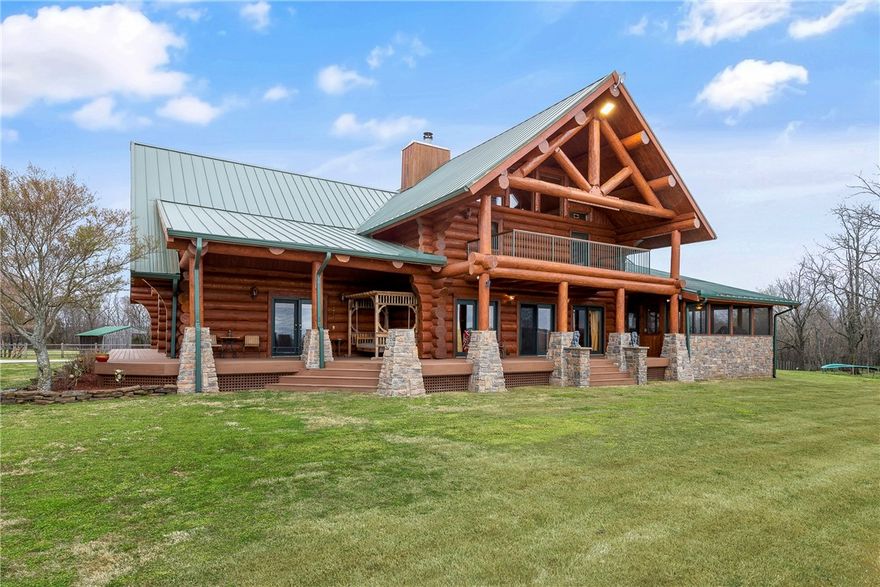 CUSTOM LOG HOME/RESORT/RETREAT  From the time you drive up thru the private gate to the entrance into the Home, the custom light fixture and front door & you enter the home, it's the WOW factor. This home is one of a kind. Featuring a large master suite and bath like no other. His & Her vanities, double shower heads & jetted tub with radiant floor heating. Two guest suites with private bathrooms upstairs. 28 ft cathedral ceilings in Great room with beautiful stone,& cast iron pellet stove.  Home situated on a hilltop on approx 87 acres with views of the Boston Mountains and a creek below.   Outdoor Kitchen with Smoker, built-in grill, Ref. & sink. The property has 3 ponds, 4 stall horse barn with heated tack room, ATV Trails & your owe shooting Range. Metal roof 2 yrs old & in the last 6 months entire outside of home sand blasted & resealed. Property has beautiful Bluffs with 150 year old trees. And the list goes on.  The only way to appreciate this property and it's natural beauty, is to see it.