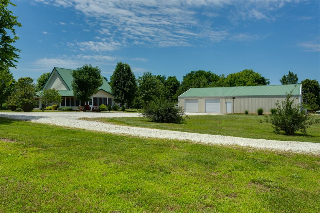 Custom Built home in 2005 sitting on 2 acres MOL this home has a shop and garage combo that is 2800 sq ft. equipped with office and bathroom. This home will not last long and with all the beauty that surrounds this home it is understandable. Original Owner very well kept. So many places to explore with the wrap around porch in front and 600 sq ft screened in patio. The gas grill will stay. Landscaping was a hobby and surrounds the home.