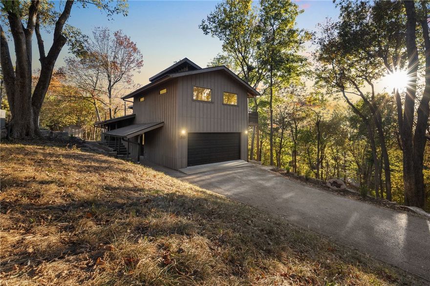 This fully remodeled 4-bed, 3-bath contemporary home embodies Mt. Sequoyah living at its finest. Floor-to-ceiling windows and glass sliding doors in the living and dining areas provide sunset views over downtown Fayetteville and the University of Arkansas. Decks at the main level and upper primary suite offer treetop sitting areas to enjoy the eastern vistas. The 2024 renovation adds high-end finishes including remodeled bathrooms with sleek tile, elegant quartz countertops, and wood accent vanity cabinets. The kitchen boasts stunning Calacatta marble countertops and a stylish waterfall bar area, equipped with Jenn-Air and Bosch appliances, under-cabinet lighting, and a new refrigerator. Smart home technology includes integrated lighting, security, irrigation, and Nest thermostats. A wooded setting offers a serene natural stone seating area. A detached storage shed and a two-car attached garage also offer convenience. This home blends modern elegance with natural tranquility—don’t miss your chance to make it yours!