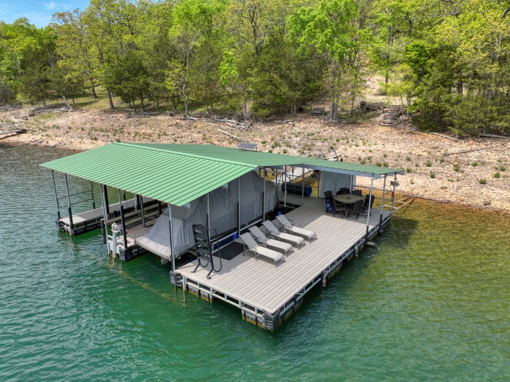 This is the amazing lake front home/dock combo that you’ve been waiting for! It has both a great view of Beaver Lake, and a rare one-owner dock! The awesome two-slip private dock has a large swim platform, composite decking, lockers, solar power, and a boat lift. Depending on the lake level, the very low Corps-line of this lot is sometimes in the water, allowing you to drive very close to the dock! The home has been updated recently and has great views of Beaver Lake through it’s huge windows and from it’s very large upper and lower covered decks. Granite island and stainless appliances in the kitchen, wood flooring throughout the home, and a wood burning stove come together to create a comfortable and calm feeling. This home is equipped to sleep 10, so bring your friends and family! Located on paved road access and is near Beaver Dam, the White River, Starkey Marina, and the excellent restaurants and events of Eureka Springs! This home is being sold with all furniture and furnishings, except for personal items.