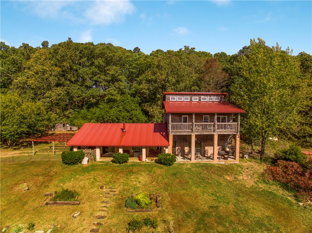 Beautiful 4 bedroom 2 bath well-built home nestled on 36.4 acres. This property would be a great homestead or hunting club! It borders over 500 acres of Ozark National Forest that can be hiked or hunted on. Home features covered front porch & 2nd story balcony, spacious rooms, geothermal heating/cooling, wood burning stove, custom cabinets & 10' ceilings. Acreage is fenced, has abundant wildlife, a large fully stocked pond & walking/riding trails throughout! 24 X 40’ barn with a 12 X 15' concreted floor shop inside. Downstairs bedroom has been plumbed out for a bathroom.
