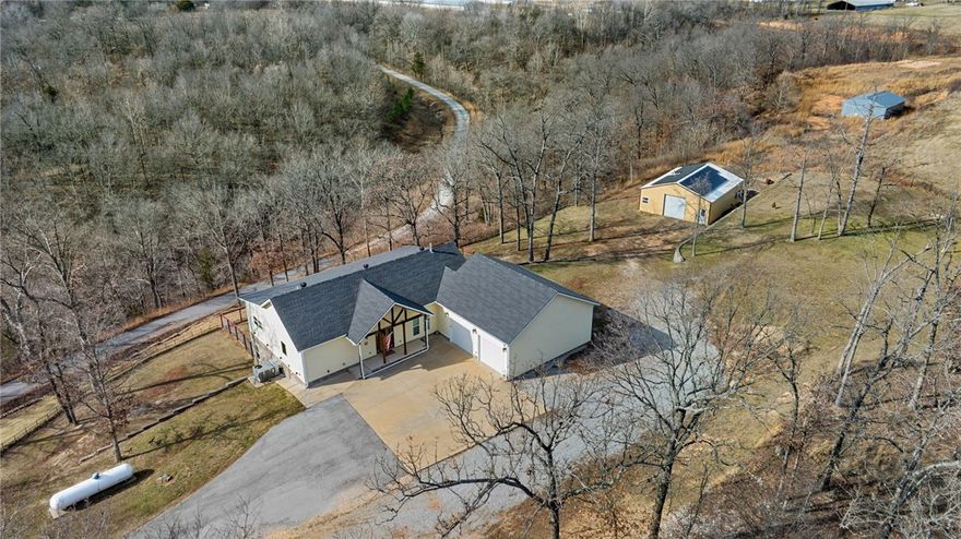 Nestled quietly outside city limits, but within 35 minutes of Downtown Bentonville, this home blends country charm with modern comfort. The home features a paid off whole home solar system and an insulated 30x40 shop with mini split perfect for tools, vehicles or hobbies. The generous floorplan spans over 2,700 square feet with three bedrooms and two and a half baths, giving a perfect balance of private and shared living areas. The main level features the primary bedroom, and the other two bedrooms are downstairs. Whole Home Solar System installed in 2025 and conveys with the property, with the exception of the battery backup system. The property’s large acreage suits multiple uses, whether you want room for gardens, outdoor entertaining, animals, or future outbuildings. Additional hookup for washer/dryer downstairs. Water system features a Softener, Iron Filter, Sediment Filter, UV Filter and Reverse Osmosis drinking system in the home, and is serviced by Culligan Water.