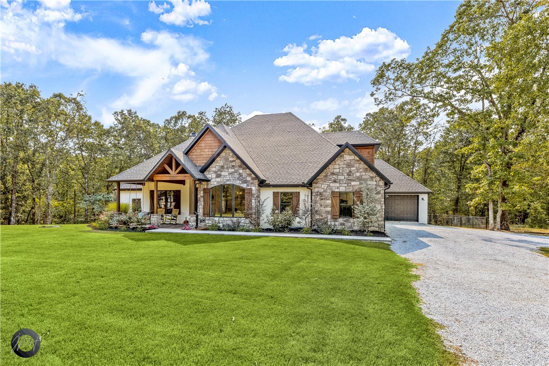 Beautiful custom home in West Fayetteville on approximately 11.5 wooded acres. Located about 10 minutes from I-49. Home features a covered front porch with a porch swing to relax and enjoy the views. The large covered back porch is great for entertaining with a sink, grilling area, and stone fireplace. The home has 4 bedrooms, 3.5 baths, and a 3 car garage. The master bath features a large shower with 2 shower heads, jacuzzi tub, and walk-in closet. Upstairs you'll find a large bonus room that could be used as guest room or playroom, a full bath, and a large walk-in closet. The home has granite countertops, instant hot water, black stainless electric appliances, and new carpet. You'll have tons of storage in walk-in closets, butler's pantry, and attic. Outside you'll find a fenced backyard, pond, and chicken coop. There is a covered area for parking RVs and a new 1,440 sf shop with 3 large bay doors. Also, a dog wash area in the 3rd car garage. You don't want to miss this one! Agent owned.