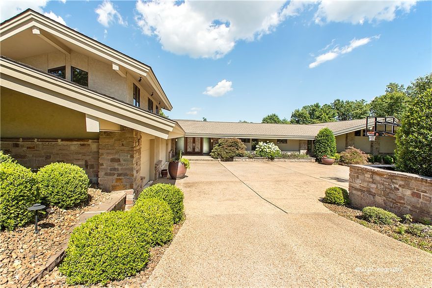 Unbelievable architecturally designed home in the mid century style of Frank Lloyd Wright!  Stone columns and glass reflect wonderful warmth and appeal for entertaining and gracious living.  Gate golf community.  Fabulous amenities include home audio system, heated floors in living and Master bath, water softening system throughout entire home, geo thermal system, 2 full kitchens, media room, pool, built-in gas grill and bonus rooms.  Don't miss this opportunity to own an architectural masterpiece!