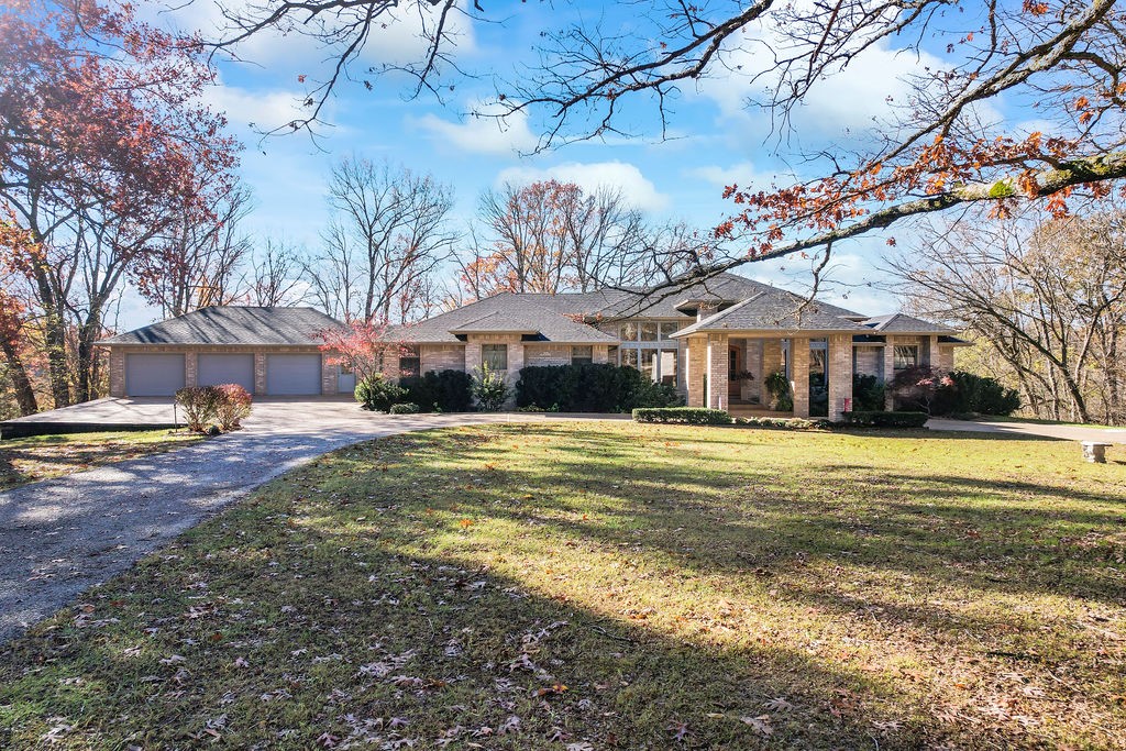 Truly amazing views from this estate home on nearly 64 acres. Secluded, yet close to town - <15 min to DT Rogers and <20 min to DT Bentonville. Home features beautiful wood floors, two living spaces, and a kitchen made for hosting. His and hers offices, a sunroom, formal dining, two master bedrooms, big closets. Expansive deck spaces overlook the backyard. Attached three car garage and mudroom. 40x60 shop of your dreams designed with tall doors for RV storage/use with RV septic, electric, water hookups inside. Shop also features an office space and full bath w/shower. Additional loafing shed used for horses. Beautiful property you've got to see!