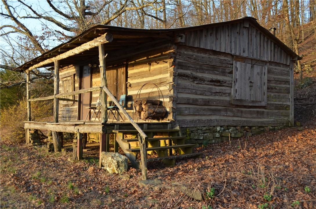 This property is an outdoor enthusiast's paradise! A log cabin (1870) originally used as a post office was reconstructed to this location. The cabin faces East allowing for sunrise views of Walnut Valley. One mile from the Upper Buffalo Headwaters. Part of the Ozark National Forest. Forty miles of biking trails (Upper Buffalo). Visit numerous waterfalls: Glory Hole (3 minutes), Magnolia Falls (10 minutes), Triple Falls, Hemmed-In-Hollow, Haw Creek Falls (originally in the top ten hiking trails in the USA). Hike famous Hawksbill Crag (Whitaker Point). Visit Eden Falls Cave, Lost Valley, Boxley Valley, Ponca Valley, or take in the elk preserve. Visit Arkansas Natural Bridge, Pedestal Rock, or King's Bluff. Canoe the Buffalo or King River. Thie would be a wonderful property for weekend get-a-ways, or a profitable short-term rental or turn the two-story storage building into a tiny home. Great potential here! Think honeymoon cabin, peacefully relax and recharge, or energize your outdoor non-stop adventures!