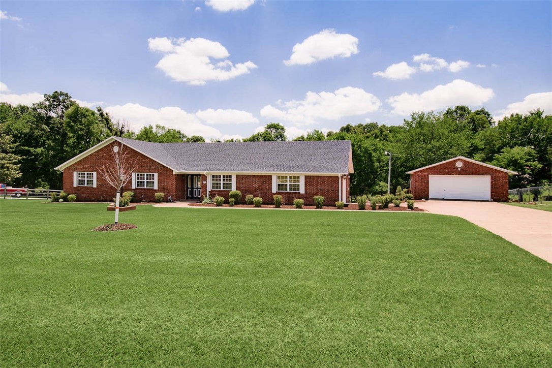 This beautiful well maintained home is nestled on 1.8 acres. Come relax on the back deck and enjoy the wildlife while still having easy access to shopping, restaurants and I-49. This home is unique with built ins, a large utility room, brick fireplace, a vanity in the main bedroom and a large detached brick shop.