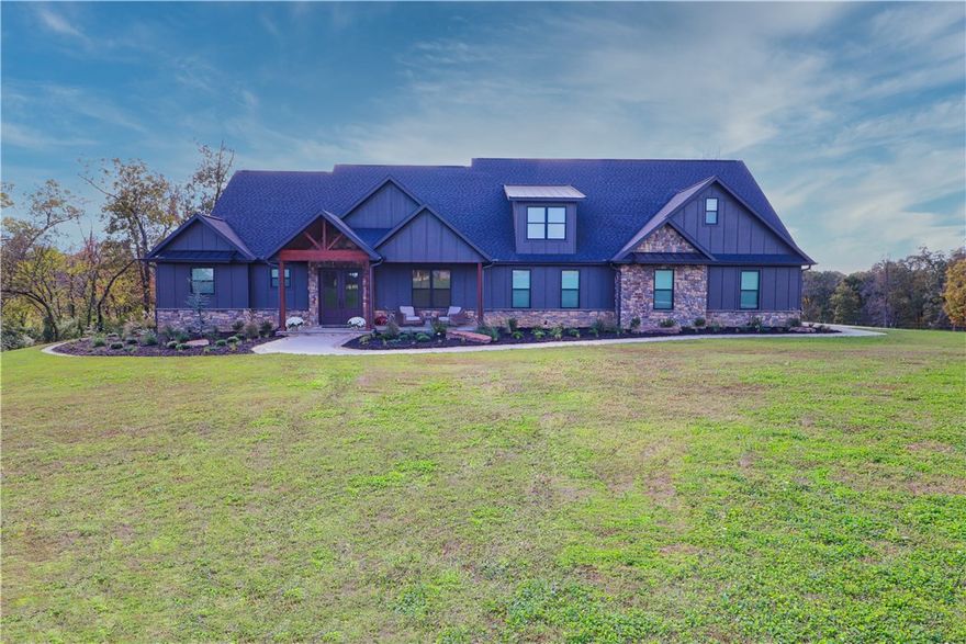 Craftsmanship & comfort converge in this 3,790 SF custom-built masterpiece on 3.2 acres in W Sdale/Tontitown. Designed with every imaginable upgrade and an open layout perfect for entertaining or everyday living. The kitchen features a commercial gas range w/double oven, pot filler, & appliance garage. The primary offers a spa-inspired bath—tiled pebble shower w/dual heads & rain head + an infrared sauna large enough to recline. Safe room w/poured concrete walls & Fort Knox vault door. Home office offers custom builtins, elegant millwork & French doors. The utility suite adds practical luxury w/custom cabinetry, drop zone, dog wash & kennel. Oversized 4-car features 3 27-ft-deep bays for 1-ton trucks or boats. Walk-out attic provides storage or future living space. The modern exterior pairs dark siding, timber accents & stone details against scenic countryside. Additional acreage available. Minutes from the new 612 Bypass, this home delivers rare tranquility, convenience & unmatched custom quality.Agent Owned