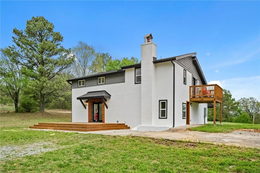 This completely remodeled hilltop residence has an amazing view of the Ozarks to the south and east, offering a one of a kind property experience. The Primary Bedroom features it's own private elevated deck to take in the surrounding beauty. The Primary Bathroom provides a serene retreat, featuring a deep soaking tub completely encompassed by the fully tiled walk in shower. This spa quality bathroom offers a refreshing experience, with a lighted mirror above the double vanity, ensuring convenience and comfort for daily routines. The kitchen invites culinary exploration with its double oven and stovetop on a large kitchen island that provides ample space for preparing meals or gathering. Granite countertops offer a refined surface, harmonizing nicely with the shaker cabinets, creating a stunning kitchen space designed for both utility and beauty. With 4 total Bedrooms and 3 Full Baths, there's plenty of room. Plus, the location is within an easy 10 minute drive into Fayetteville. ADDITIONAL PARCELS AVAILABLE.