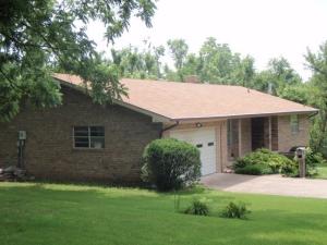 Terrific setting for this one-owner brick home featuring 3 BR 2 1/2 baths, near new Trane high efficiency furnace, AC, and water heater, large unfinished basement with drive-in door, on 1.75 ac m/l in town at the end of the street. Home was custom build by Jack Colston. Nice big den off kitchen, huge living room, all bedrooms are very nice size. 2 full baths on main level and bath with shower & commode in basement. Yard is surrounded by large walnut trees. Covered porch in back. Most of land is wooded.