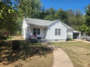 Nice cottage home on a good size corner lot with lots of pluses!Plenty yard with sidewalks leading front and back, front porch, garage/shop in back, attached one car carport fenced back yard are just some of the amenities. Inside lots of charm, big kitchen, wood floor in living room, big bathroom. plenty of space and potential to make this one just what you are dreaming of.