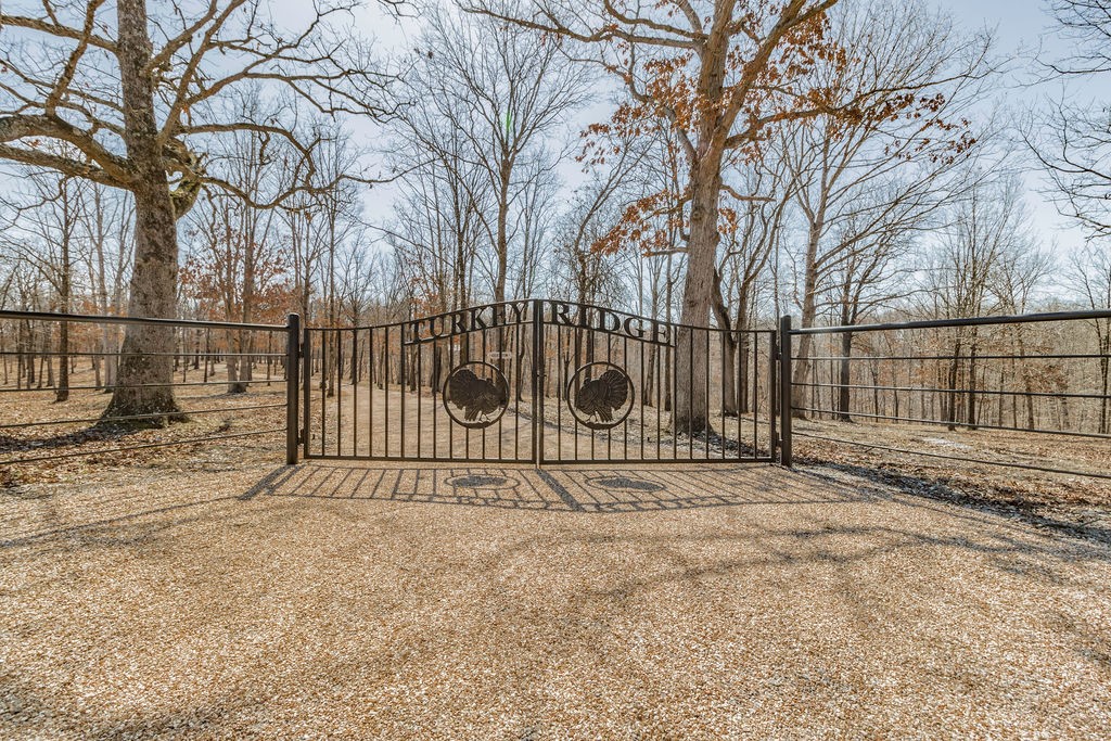 Over 583 acres of hunting paradise, affectionately known as Turkey Ridge. Just 15-20 minutes from Bentonville, you won't find this many acres this close to town anywhere else. Gated entry and paved road access. The 1,848 Square Foot lodge has 3 bedrooms and 3 full baths, a beautiful open kitchen and bar, Meat hanging walk-in cooler, and a full wrap around deck. 16x16 outdoor kitchen pavilion with wood fireplace. Covered parking for 2+cars. AND a 30x40 wood barn/shop. Greater property features several active springs providing year round live water. Expansive road system not usually seen on hunting land. Easily drive a 4WD vehicle throughout the property (see attached map and photos). Lots of frontage on Kelly Pond Rd. List agent must be present for all showings. See also Residential Listing MLs# 1206509