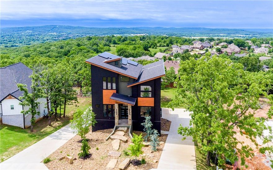 Welcome to this stunning custom-built home on a spacious half-acre lot in the highly sought-after Hyland Park subdivision. Designed for both comfort and style, this one-of-a-kind property offers panoramic views of Fayetteville through expansive picture windows and from a rooftop balcony wired for a hot tub and heaters. Inside, enjoy a custom waterfall island with quartz countertops, marble-look tile, luxury vinyl plank flooring, and double ovens. Thoughtful upgrades include solar panels (covering most of the electric bill), Sonos surround sound, whole-home water filtration, EV charger, tankless water heater, laundry chute, and customizable exterior lighting. The drive-through garage and floating staircase add even more appeal, along with a 500 sq ft unfinished basement. With 3 bedrooms, 3.5 baths, an office, and a large media/game room, this home blends modern design with everyday convenience. A rare opportunity you won’t want to miss!