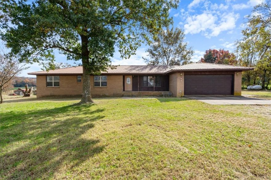 Charming Country Home with Scenic Views on Nearly an Acre. Enjoy peaceful country living in this spacious 4-bedroom, 2-bath home set on a beautiful .89-acre lot. Inside, you’ll find generously sized bedrooms, a formal living room, and a large eat-in kitchen with an adjoining dining area—perfect for family gatherings. The cozy family room with a fireplace creates a warm, inviting space for relaxing evenings. Additional features include a large utility room, a two-car garage, and a versatile 10x16 outbuilding with double doors, loft and a small porch, ideal for a workshop, hobby space, or storage. Step outside to take in sweeping front and back views from your expansive back deck, offering the perfect setting for entertaining or simply enjoying the peaceful surroundings. Ozark Go at the property!