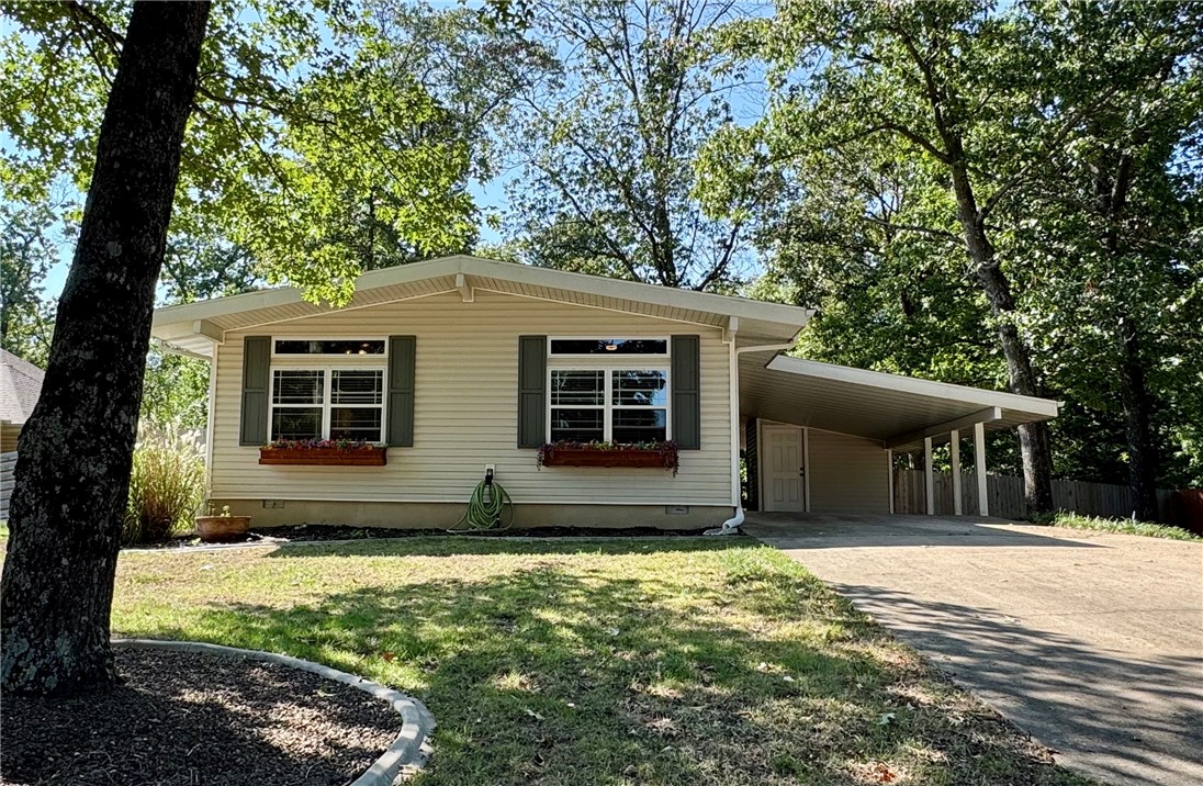 Cute & cozy, this charming 2-bed home in Bella Vista is ready for new owners! Step inside to a refreshed interior with wood-look tile floors that lead you into the living area, where a cozy wood-burning fireplace is perfect for chilly nights. The spacious kitchen features a glass induction cooktop & a built-in oven, making meal prep a breeze. The primary bedroom, located on one side of the house, includes a full ensuite bath. A second bedroom on the other side of the house is located next to a second full bath. Outside is a true entertainer's paradise. The enormous 2-tiered deck overlooks a flat, fenced-in yard, offering ample space for gatherings. A dedicated firepit area provides a perfect spot for cozy evenings. The property also has a "she-shed" or "man-cave" with electric and cabinets that stay. Hot tub electrical is in place as well. Already connected to sewer with low maintenance exterior. Mountain biker? So close to The Back 40- .6 miles! View the virtual tour then schedule a showing to see it in person!
