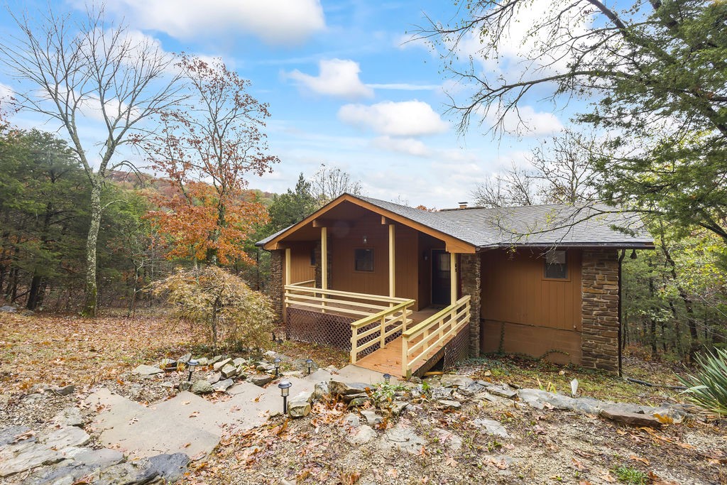 Cabin Style home in the woods! This cabin in the woods will surprise you with the amount of living space it actually has. The main floor has 2 Bedrooms and 2 full baths, galley kitchen, living room with native stone fireplace, utility room with W/D and nice sized deck for watching wildlife. Downstairs is another living area/additional bedroom, walk in closet and a full bath. This property could be an incredible private residence, getaway or used for investment opportunities. Not far from 18 hole golf course. Borders common or wildlife area in back. Vacant easy to show!