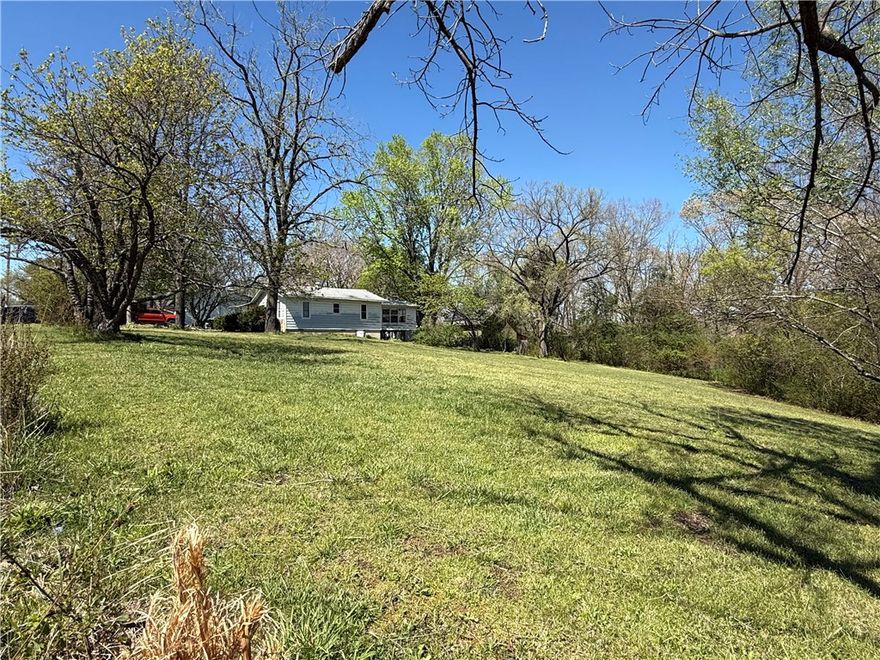 Surrounded by mature trees and sitting on a large ONE plus acre lot you will find this older, very clean and well maintained home. Heating and air conditioning is only 6 years old.  Plenty of space for tinkering and hobbies, there are two connected workshops complete with workbenches and room enough for parking large toys such as a full size RV and boat.  Shop is about 40ft x 60ft. Close to the Monte Ne restaurant and boat ramp.  No showings until Tuesday, April 7.