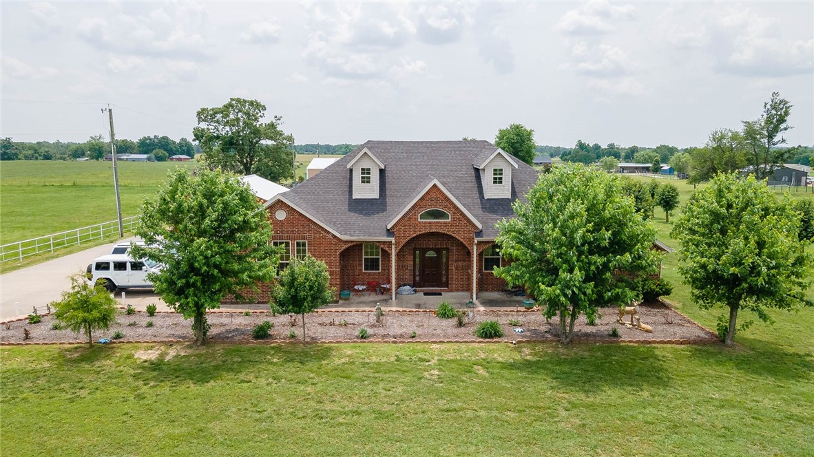 Welcome to this stunning property nestled on 3.09 acres of picturesque land, offering a perfect blend of rural serenity & convenient access to town. Inside you'll find pristine marble floors that flow throughout the main living areas. Living Room features a stacked stone fireplace, creating a cozy & inviting ambiance for relaxing evenings. Open floor plan seamlessly connects living room, dining area, & kitchen, making it ideal for entertaining guests or enjoying quality time with loved ones. Kitchen boasts stainless appliances, large island, & NEW dishwasher & stove. Retreat to the Owner's Suite, where a walk-in shower awaits for a spa-like experience. Other notable features of this home include a new septic pump, storm shelter, gated entry, Formal Dining, & covered gazebo patio with hot tub. Property also includes a 40x80 shop, ideal for hobbies or storage needs, and NEW 24x36 Shop that is the perfect entertainment area & loaded with amenities! Embrace the charm, luxury, & rural feel of this remarkable property.