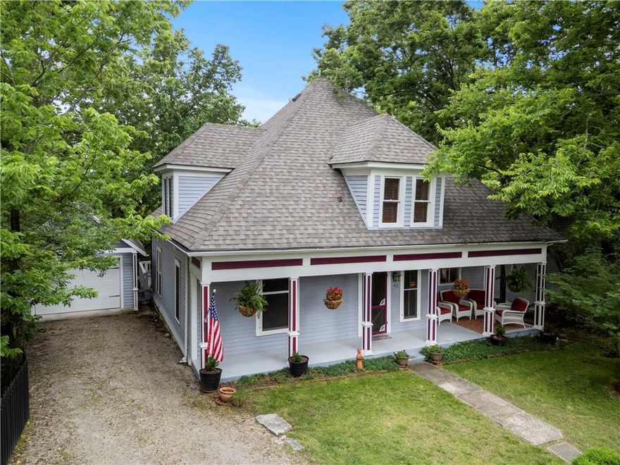 You'll love the curb appeal of this stunning two-story cottage with its inviting front porch and dormer windows. The porch provides the perfect spot to enjoy this secluded neighborhood off the Upper Historic Loop. The front door opens into a foyer with an original staircase, stained glass lighting and a coat closet. The spacious living and dining room have beautiful wood floors and double French doors. The kitchen has plenty of cabinets for storage, Corian counters and a lighted vent hood. The kitchen door opens onto a large covered porch and wooden deck -- the perfect spot for entertaining. A bedroom and a full bath complete the main level living area. There are two guest bedrooms and a bath on the second level and a fourth bedroom currently used as a tv room. There are several large storage closets. The one-car garage is oversized and has an area for storage or a workbench. New roof in 2023. Walk to your favorite downtown shops and restaurants, the community center and the farmer's market.
