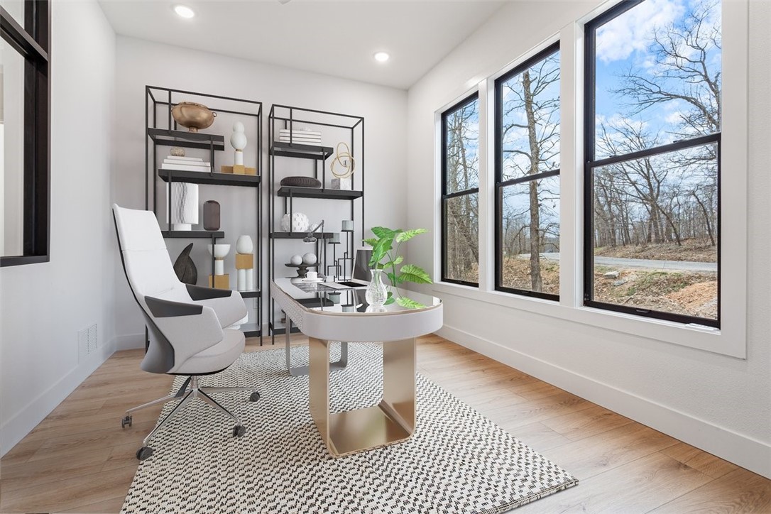 This Bella Vista beauty offers the perfect mix of comfort, charm, and convenience—just steps from trails, golf, and peaceful surroundings. Inside, you’ll find a spacious, light-filled great room with wood beams, a custom accent wall, and an electric fireplace that sets the tone for cozy evenings. The dedicated office with glass walls is perfect for remote work without feeling closed off. The primary suite is a true retreat with double closets and a tray ceiling. Downstairs, enjoy a second living area, walkout basement, and two decks—plenty of room to host or unwind. Energy efficiency meets modern living with Marvin windows, Nest smart thermostats, and a 220V EV charging port in the garage. Prefer a tub? A bathtub can be added to the second bathroom with ease. Bonus: one-year mechanical warranty included. All this just 0.2 miles from Tunnel Vision Trail, 2.4 miles from Kingswood Golf Course, and 10 minutes to I-49.