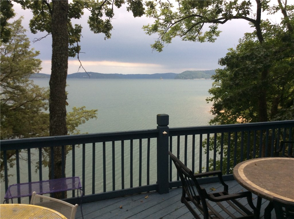 This home has a fantastic full lake view, and great lake access, new steps down to CORPS line. Plenty of bedrooms and space for the whole family. Or would make a great rental if you so desire; and would help make your payment. Most furnishings and appliances may convey with acceptable offer. The sun room is the perfect place to gather and watch lake action. Or out on the 27' x 14' family deck. Or have some privacy on the large 22' x 20' private upper balcony deck. Outbuilding for storage. Come on out to Lost Bridge Village, to your home almost right on the water.