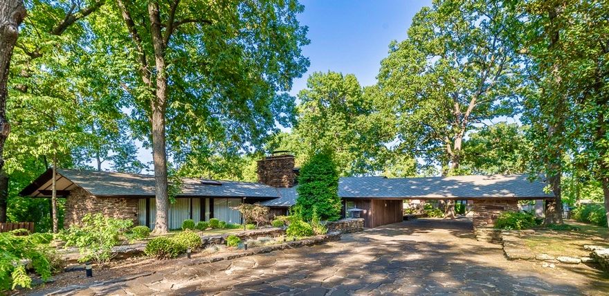 A rare opportunity! Constructed in 1964, this home is in impeccable condition. Preserving the original design to honor E. Fay Jones architectural style, this property offers all the features one would desire in a mid-century modern home. Adorned with Arkansas Native stone, panoramic views, distinctive flagstone floors, and floor-to-ceiling Walnut tongue and groove plank walls, this home is a masterpiece. Thoughtfully updated to maintain the integrity of the original builder, it boasts a new 50-year roof, HVAC system with new gas lines, custom RH drapes, a sizable workstation sink, and KitchenAid appliances. The built-in furniture has been tastefully refurbished, and the original tile work, upgraded bathroom faucets and angled shower glass doors add a touch of elegance as do the custom guest bedroom sliding doors. It is truly a rare opportunity to own this exceptional home. Located on a Cul-de-sac on .66 acres, this is a home you will not want to miss and the only E. Fay Jones home in Siloam Springs.
