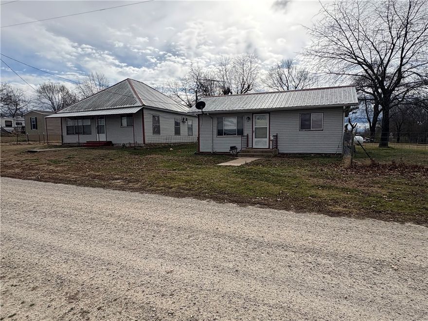 Lots of potential-2 small houses, 2 nice shops on about 1 acre then lot at Hwy143 that touches other property at corner is additional .33 acres. vacant lot beside and one across street make up approximately 1.33 acres total.  A large covered patio/huge carport next to smaller home.  This home is on well and septic.  Roof is metal on each structure...  Homes have been rented but could use some updates and source of heat needed in larger home.   Lots of property for the price.