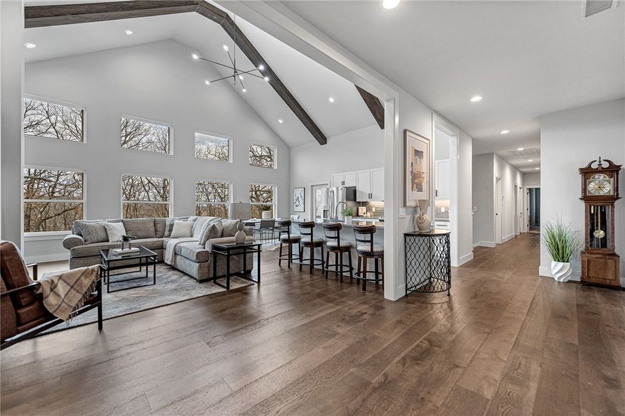 This LIKE-NEW, EXPANSIVE CUSTOM HOME offers exceptional privacy and picturesque views overlooking the Ozark mountainside. Upon entering this two-story home, you’re welcomed by soaring cathedral ceilings, abundant natural light, and open-concept living space. Designed with both relaxation and entertaining in mind, this home features multiple access points to a spacious covered back deck and patio, seamlessly connecting indoor and outdoor living. The walk-out basement provides a second living area complete with wet bar, bedroom, safe room, flex spaces ideal for home office or gym, and recreation room featuring a roll-up glass garage door. Additionally, there is an unfinished attic offering future potential for a media room or creative studio. Conveniently located just 15 minutes from the University of Arkansas and 20 minutes from the Fayetteville Downtown Square, this home delivers the perfect balance of tranquility and accessibility.