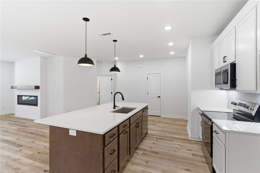 Brand new move-in ready home in Bella Vista with an unbeatable location! Walking distance to Branchwood Club House, less than 5 minutes to I-49, minutes from the Back 40 Trail System and Little Sugar Trails, and under a mile to Lake Loch Lomond for boating, fishing, and outdoor recreation. This 3-bedroom, 2-bath home features a bright open floor plan ideal for everyday living and entertaining. The kitchen offers quartz countertops, a large walk-in pantry, and modern finishes, while the spacious primary suite includes a huge walk-in closet. Enjoy peaceful wooded views as the home backs to Bella Vista POA land, providing extra privacy with no homes directly behind. Built with quality and efficiency in mind, the home includes ZIP System sheathing, hot water recirculation, and a fully insulated 2-car garage. Additional features include full guttering, installed window blinds, professional front landscaping, and a 2-year builder warranty.