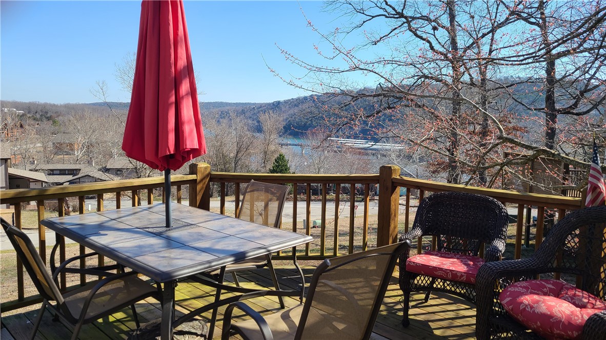 Enjoy a gorgeous lake view from this 2-bedroom, 2-bath condo with a large extended deck. The living area flows seamlessly to this large deck, where you can relax and take in the serene lake views, ideal for outdoor dining or simply unwinding. This home features a spacious layout with a fireplace, wood-like flooring, tile, and carpet throughout, creating a warm & inviting atmosphere. The kitchen boasts a retro feel perfect for meal prep & entertaining. Nice-sized bedrooms offer plenty of room for rest & relaxation. Additional highlights include a recently installed seamless metal roof and gutters for added peace of mind completed in 2025 and convenient storage space under the unit. Make this gem your home or your first short-term investment!