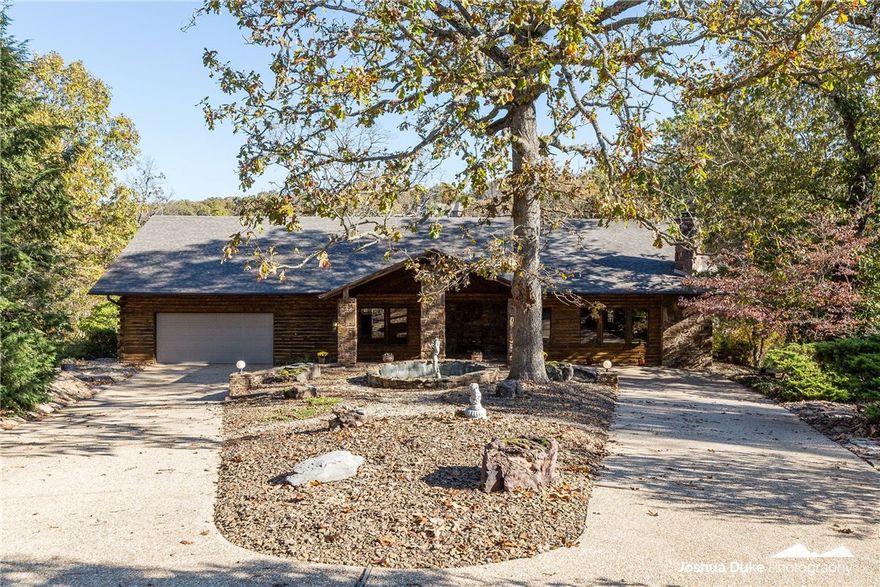 Enjoy your private oasis in this absolutely stunning lake front log home on beautiful Loch Lomond!  Super easy lake access down the rock paved trail to your personal 27' x25' two-bay boat house and 28'x17'swim dock.  Quiet cove great for swimming and fishing or relax in the private in-ground salt water pool.  Inside, the awesome cathedral ceiling towers over the living/dining area with walls of windows giving an incredible view of the lake. Or just step out onto the new composite deck and see it all. In the cool evenings, cozy up to the wood burning fireplaces in both spacious living areas.  Fabulous chef's dream kitchen w/ double oven (one's convection) - loads of cabinets and counterspace. A huge pantry, too.  Second kitchen on lower level makes poolside entertaining a breeze.  Over 190 ft shoreline!  Private office on lower level could be used as 5th bedroom.   Architectural shingle roof replaced 2021.  Conveniently located less than 10 minutes from the Bella Vista Bypass.